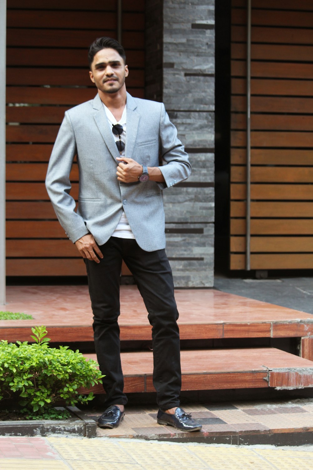 Homem com blazer claro, camiseta e calça escura